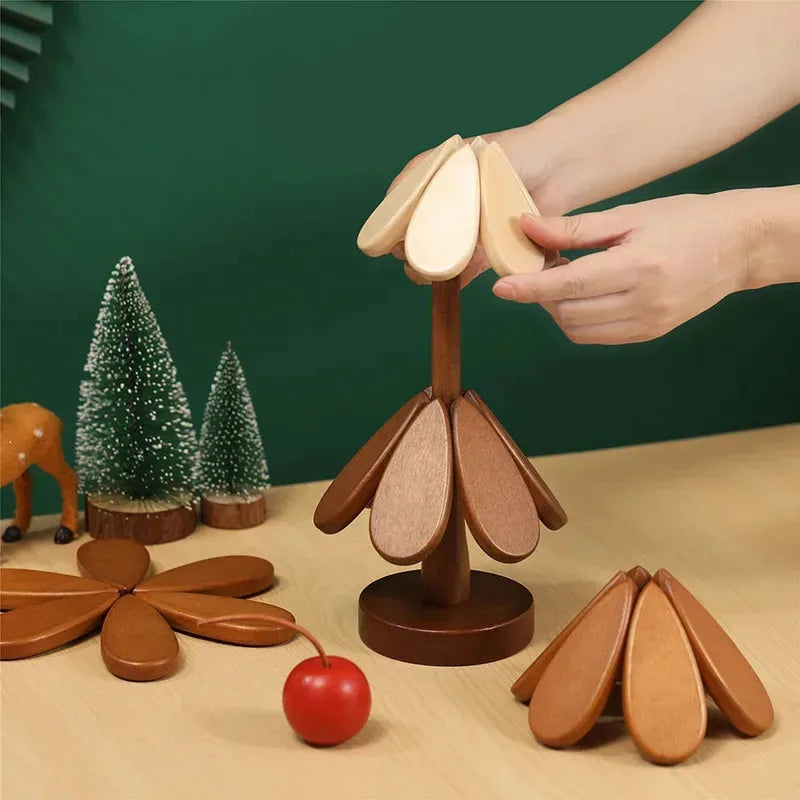 A hand is holding a natural wood foldable trivet with leaf shapes, demonstrating the heat-resistant pot mat.