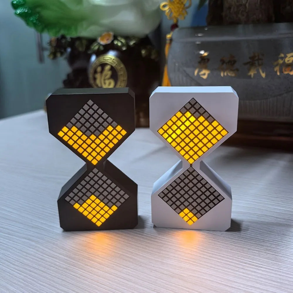 A pair of LED electronic hourglass timers, one black and one white, displaying yellow light.