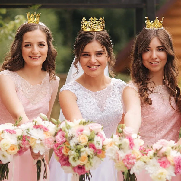 Drei junge Frauen in rosa Kleidern und goldenen Kristallperlen Mini-Krone Tortenaufsätze mit Blumensträußen