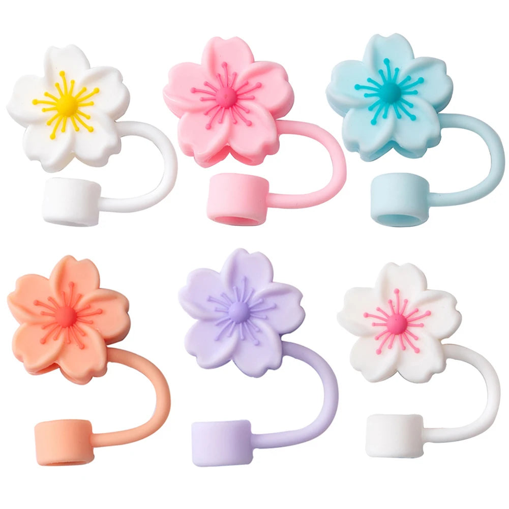 A set of five pastel colored flower straw caps for tumblers in pink, white, blue, and purple.
