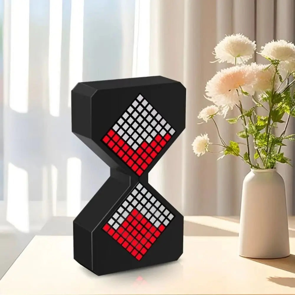 A black digital hourglass timer with a red and white checkered pattern sits on a white surface.
