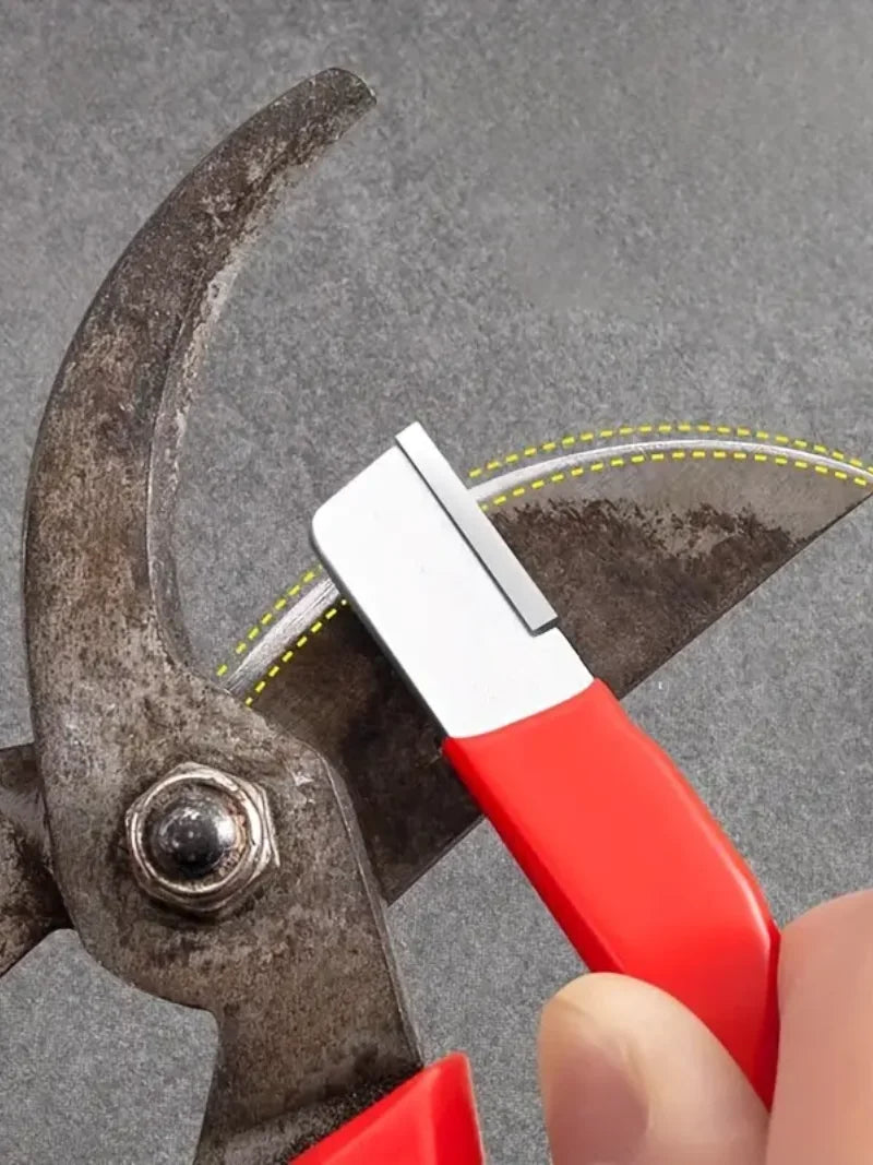 A hand holds a red knife sharpener with a silver blade against a dark metal sharpening tool.