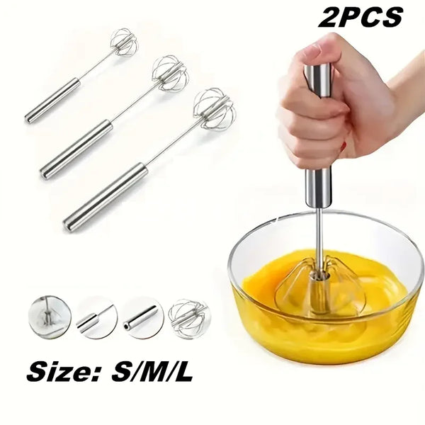 Zwei Edelstahl-Eierverquirler und eine gelbe Flüssigkeit in einer Glasschale.