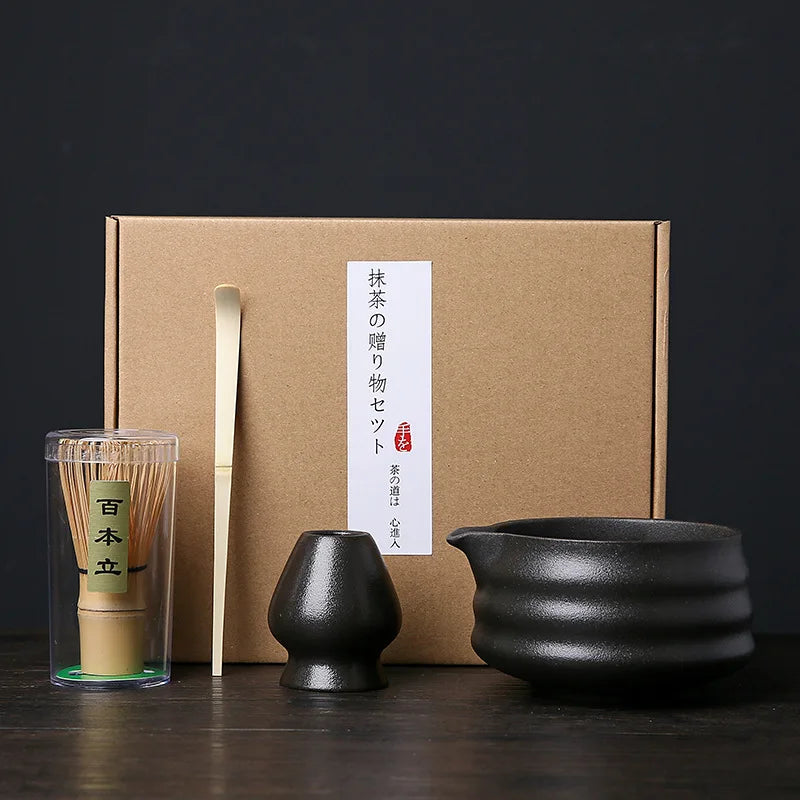 A set of Japanese matcha whisks in a light wood container placed in front of a brown cardboard box.