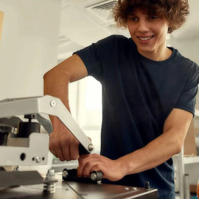 A young man in a dark shirt is operating a piece of machinery, likely related to making reusable foam insulated beverage slee