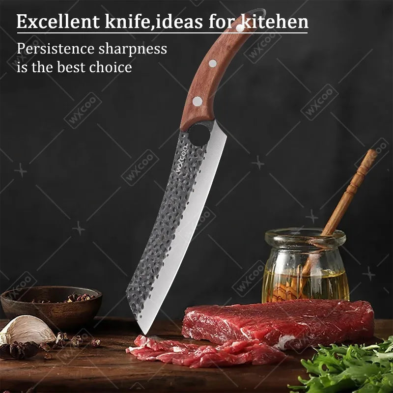 A professional stainless steel chef knife is shown next to raw red meat and fresh herbs on a wooden surface.