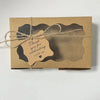 A kraft paper gift box tied with twine featuring a die-cut tag that reads Thank you for celebrating with us