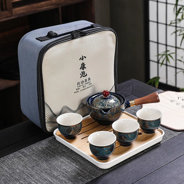 A light blue fabric pouch containing a traditional Kung Fu ceramic tea set with a wooden tray and white cups.