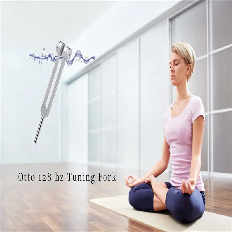 A woman meditating sits on a mat while a tuning fork is shown floating in the air.