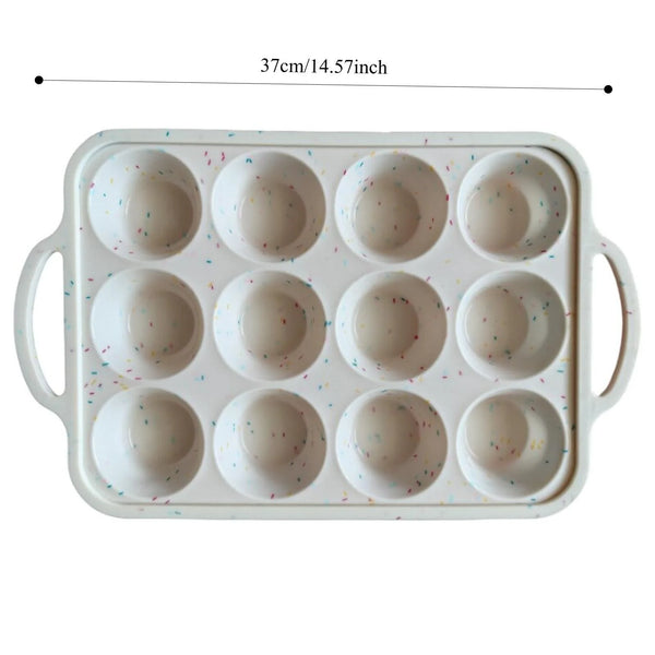 Weiße Silikon-Muffinblech mit Metallverstärkung, 12 runde Formen und bunten Streuseln.