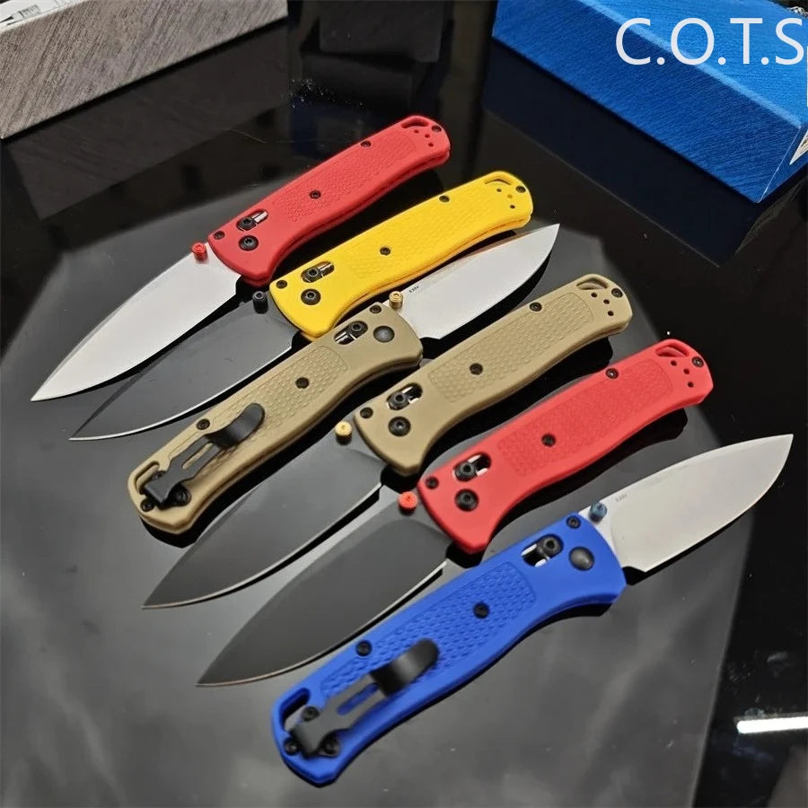 A collection of folding utility knives featuring various colored handles and 440C blades displayed on a dark surface.