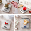A precision digital kitchen scale is shown with various food items and a red apple on its platform.
