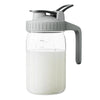 Jarra de vidrio transparente con tapa y asa gris, para jugos y bebidas.