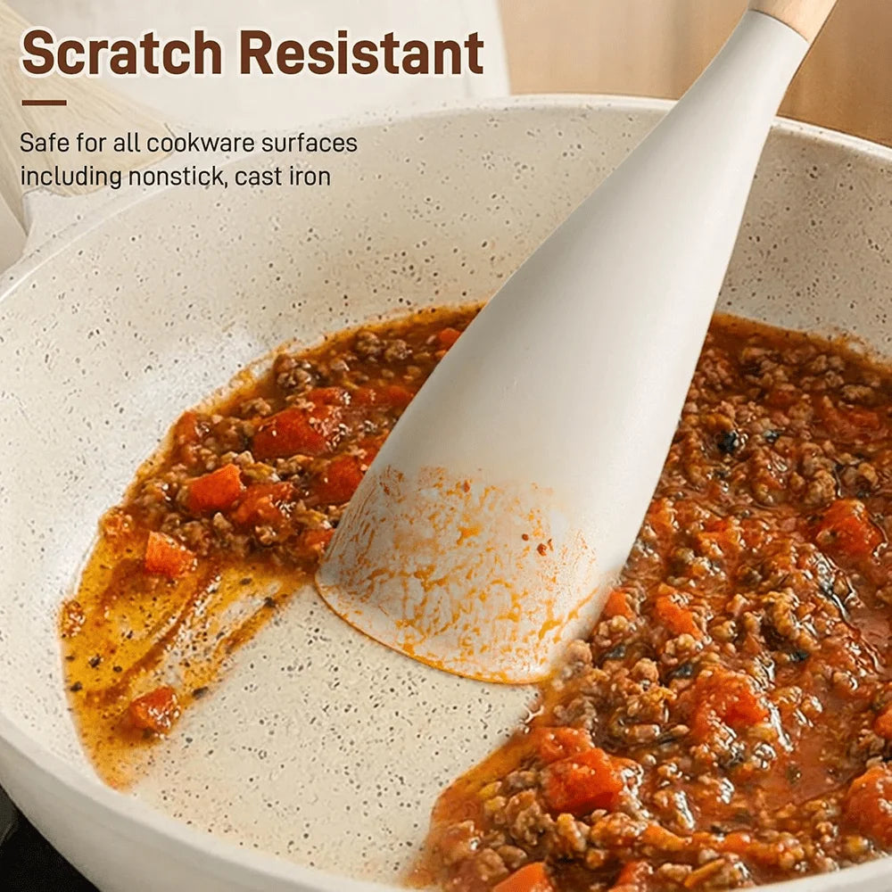 A silicone cooking spoon and spatula with a wooden handle is shown scooping food in a white cooking pot.