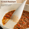 A silicone cooking spoon and spatula with a wooden handle is shown scooping food in a white cooking pot.