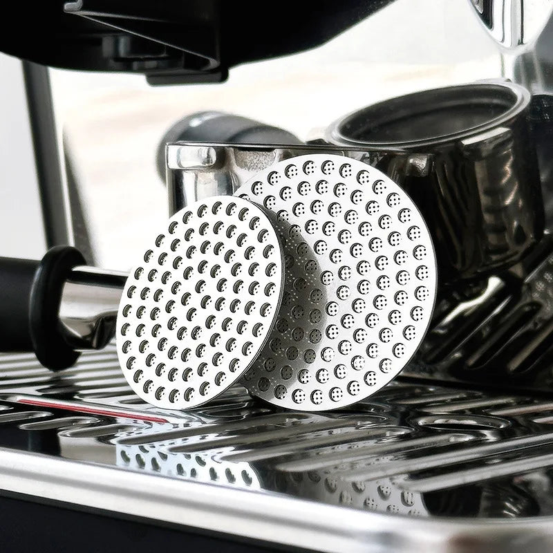 Dos pantallas reutilizables de metal para café espresso en una bandeja plateada.