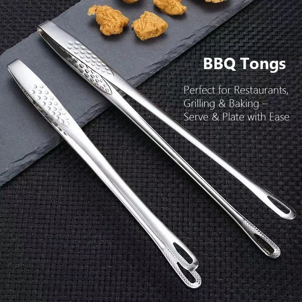 Ein Paar professioneller Edelstahl-BBQ-Zangen auf einer dunklen Oberfläche mit kleinen Speiseresten.