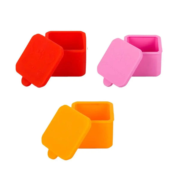 A set of three silicone food storage bowls in red, pink, and orange.