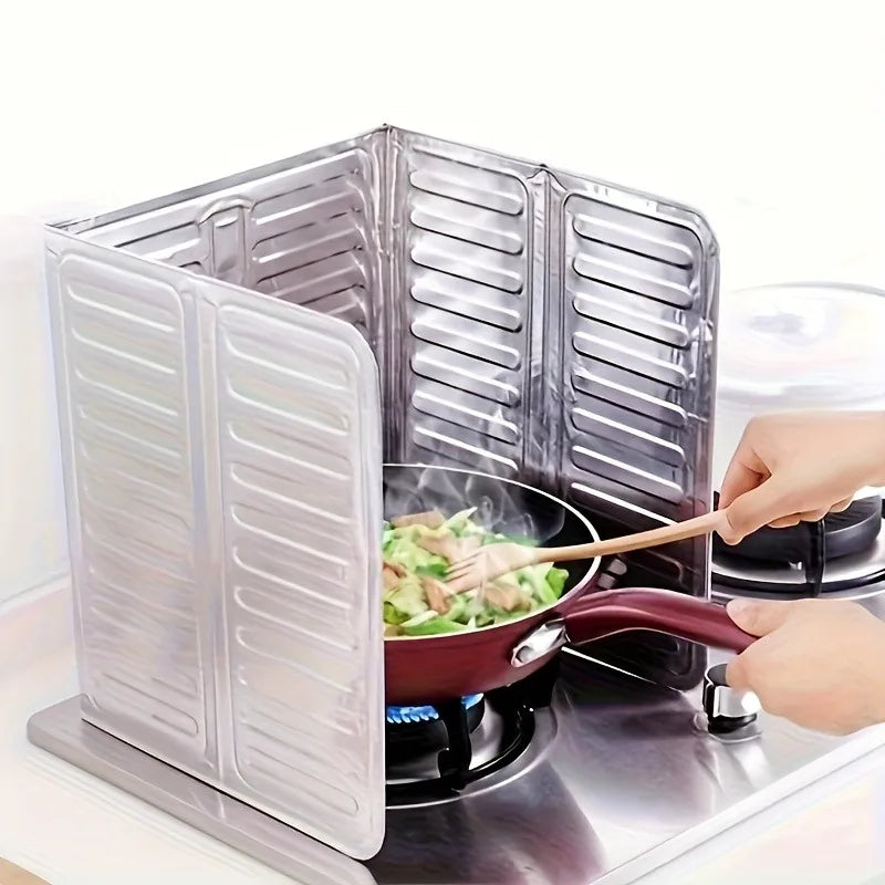 A stainless steel cooktop baffle protector is shown open, with a hand stirring food in a pan on the surface.