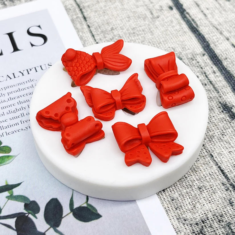 Red silicone baking molds shaped like bows and flowers for chocolate cupcakes