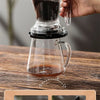 A hand pours coffee into a glass using a versatile pour over coffee dripper.