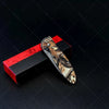 A multi-functional folding utility knife with a camouflage pattern is displayed on a black background next to its red box.
