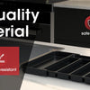 A black expandable silverware drawer organizer tray shown on a kitchen countertop.