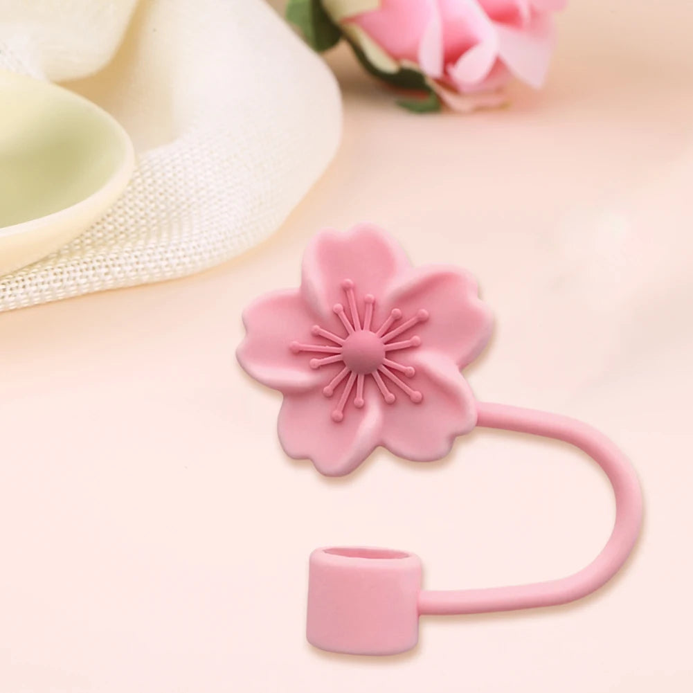 A pink flower straw cap for tumblers is shown against a light background.