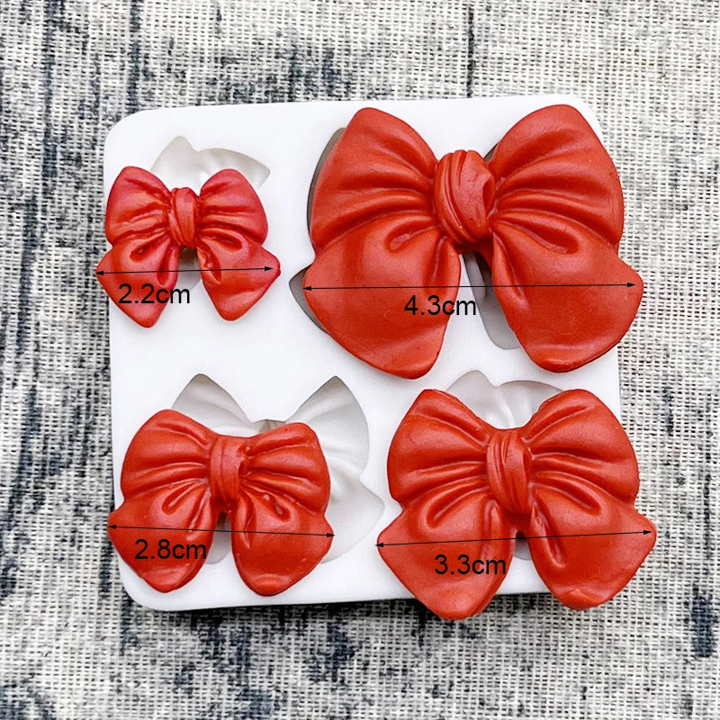 Red silicone baking molds shaped like bows for chocolate cupcakes