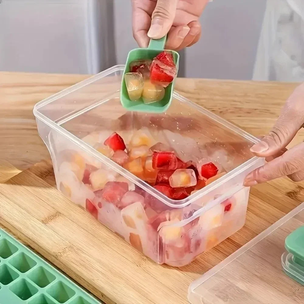 A hand is placing ice cubes into a clear plastic storage box with a lid and a green scoop on a wooden cutting board.