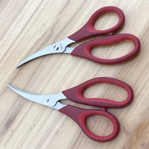 A pair of stainless steel seafood kitchen scissors with reddish-brown handles resting on a wooden surface.
