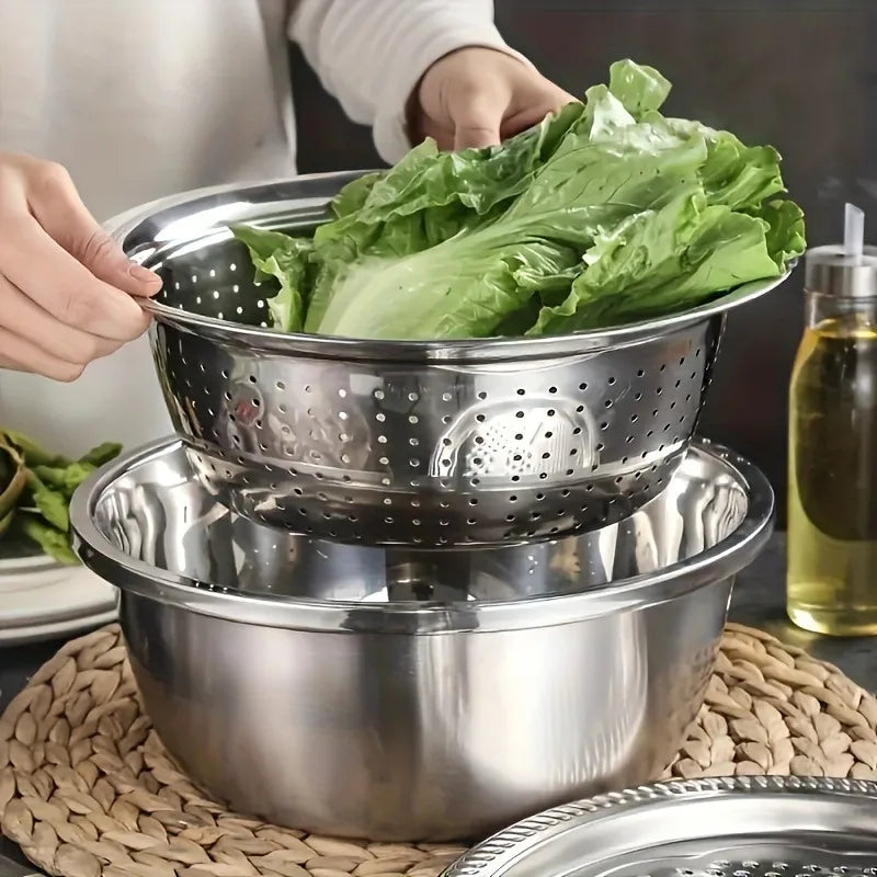 A set of three stainless steel mixing bowls with a grater and strainer are shown, being filled with green lettuce.