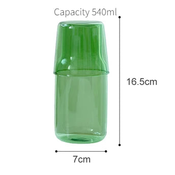 A tall, cylindrical green glass cup or mug with a slightly tapered rim.