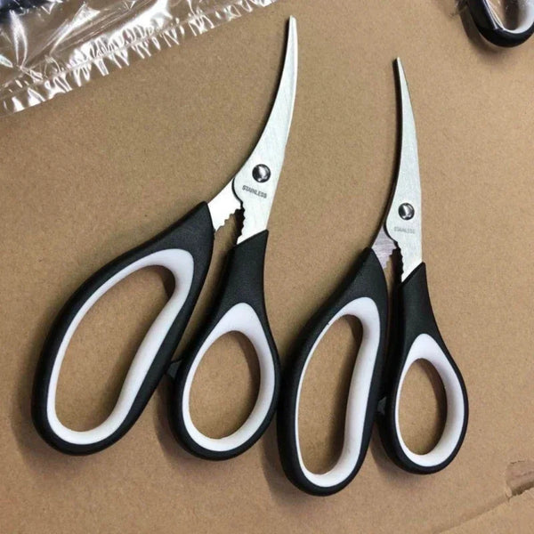 A pair of stainless steel kitchen scissors with black handles resting on brown paper.