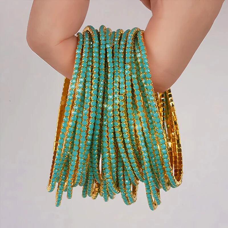 A stack of teal and gold acrylic elastic bracelets worn on a person's wrist.