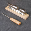 Stainless steel manual nut cracker tool with a wooden handle and metal body resting on a dark surface.