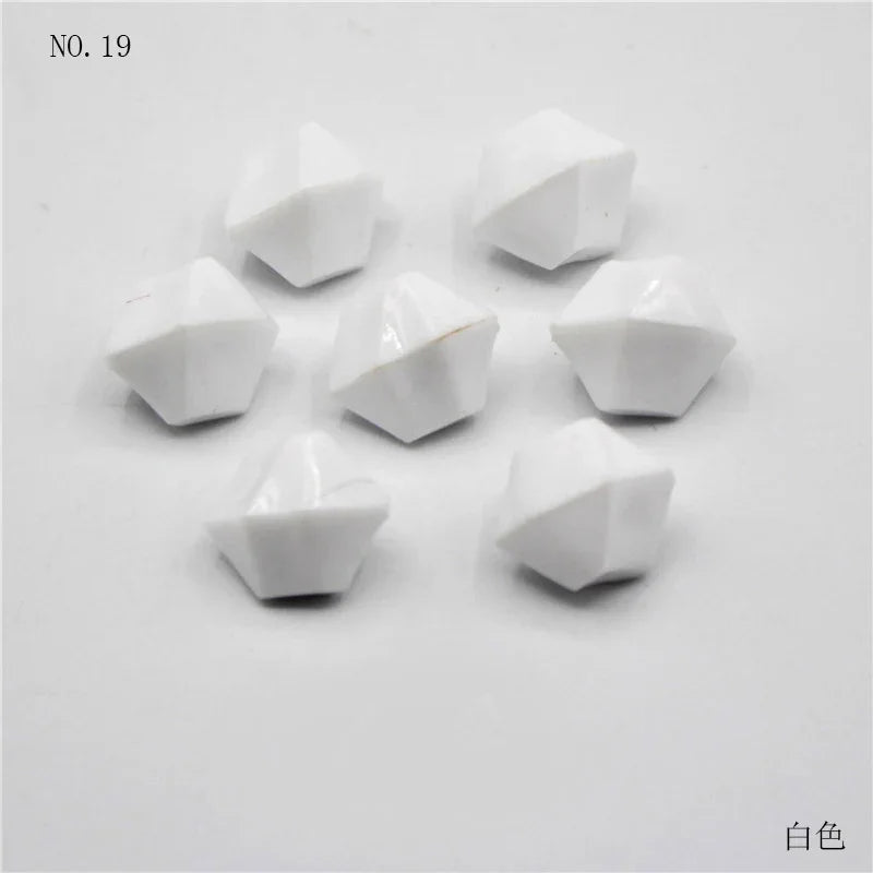 Un ensemble de 19 perles en acrylique blanc, taillées en pyramides ou triangles.