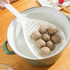 A white kitchen strainer and skimmer set is shown with several round, light brown food items inside the bowl.