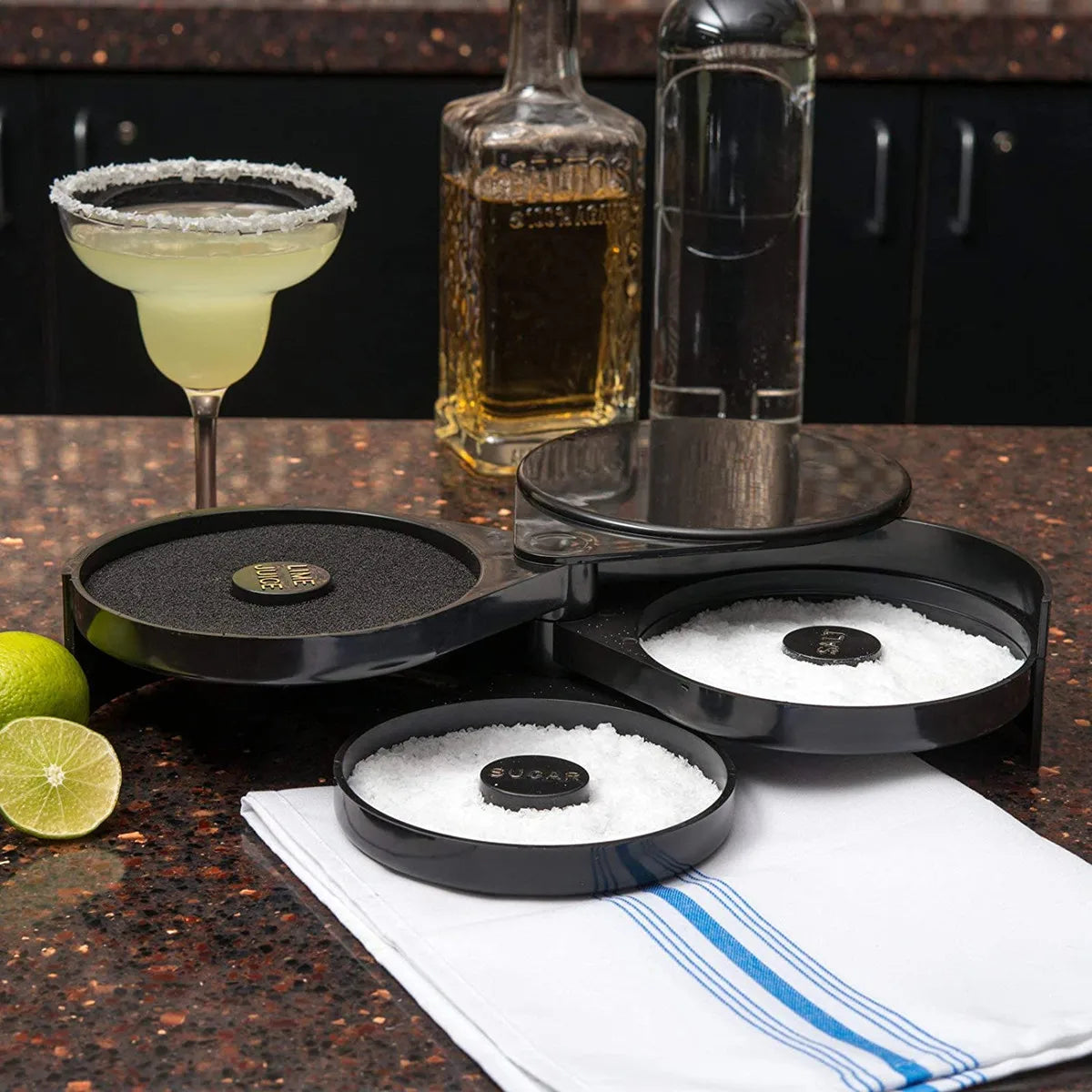A set of three bar glasses and a cocktail glass are displayed on a dark surface with salt and citrus fruit.