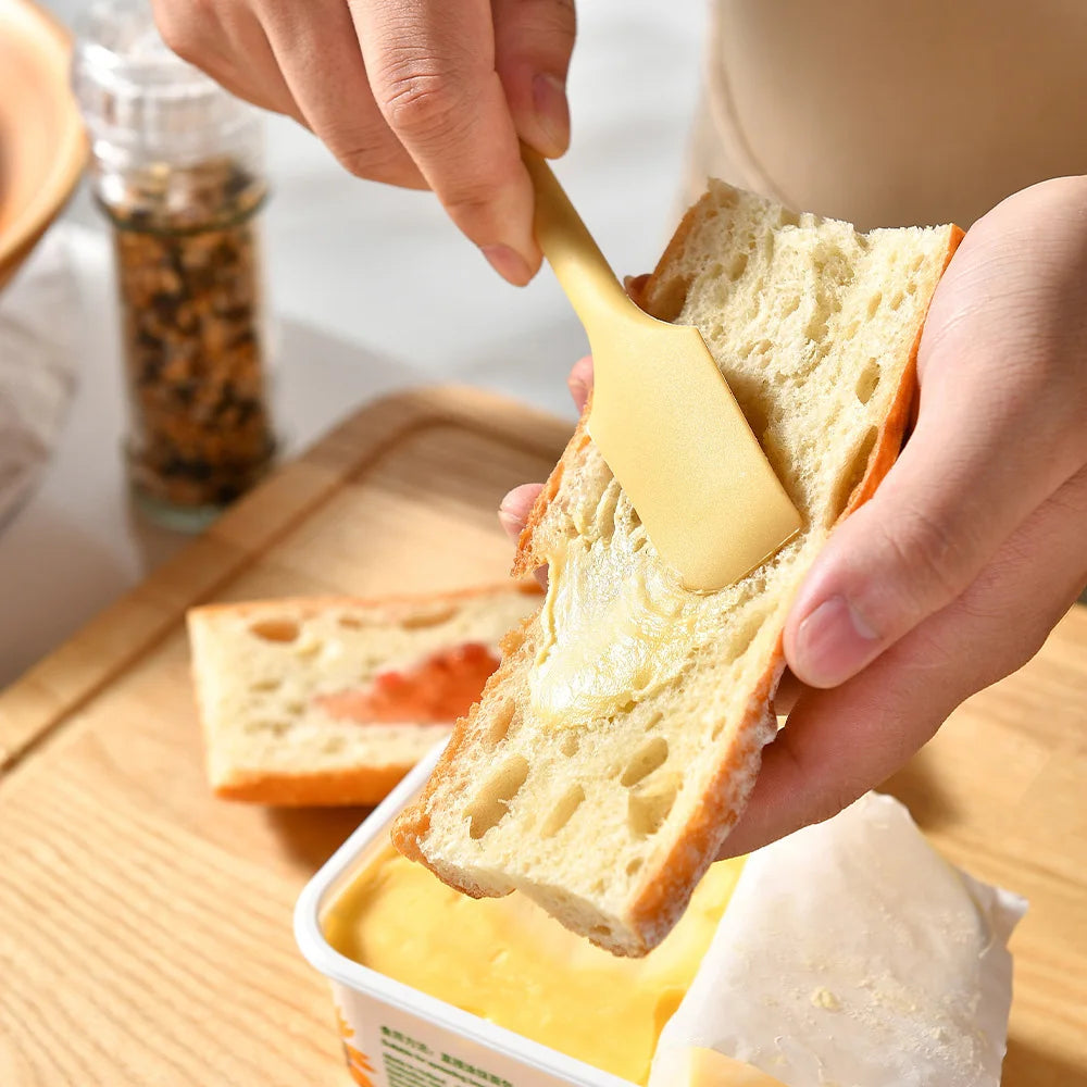 A hand is using a silicone heat resistant spoon to serve jam or rice from a container.