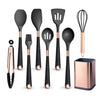A set of elegant silicone cooking utensils with gold-plated handles, including spatulas, a whisk, and a brush.