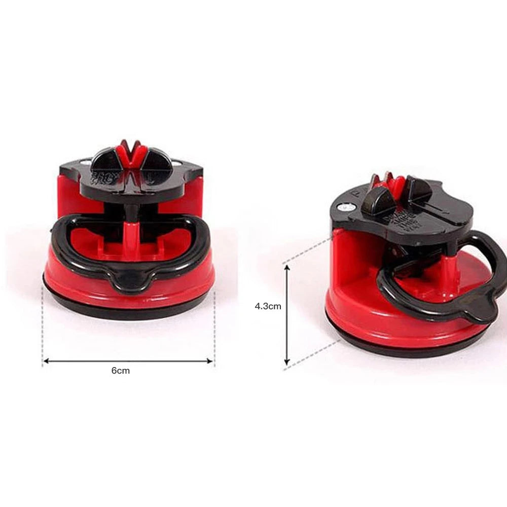 A red and black suction knife sharpener tool with a handle and base for sharpening kitchen tools.
