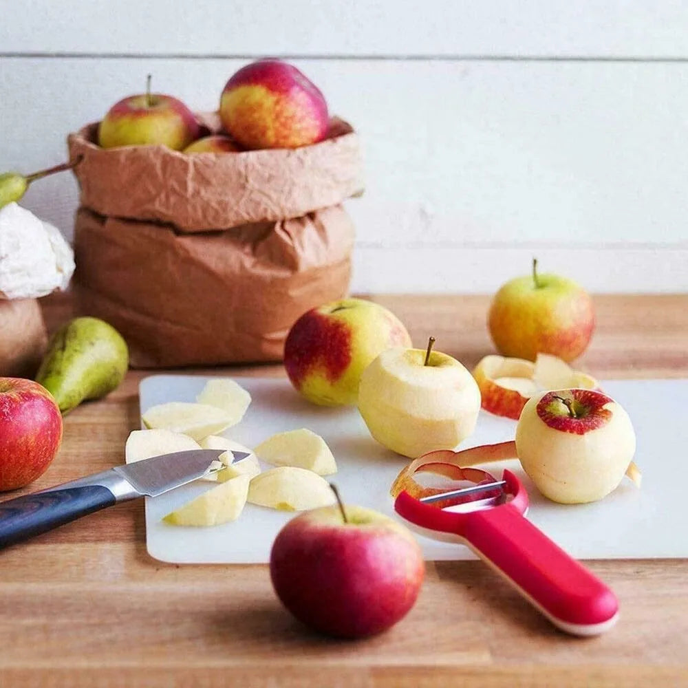 A set of colorful plastic cutting boards and apples on a wooden surface.