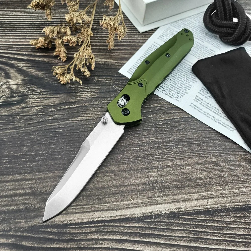 Taktisches faltbares Taschenmesser mit grünem Griff und silberner Klinge auf dunklem Holz neben Papierdokumenten.