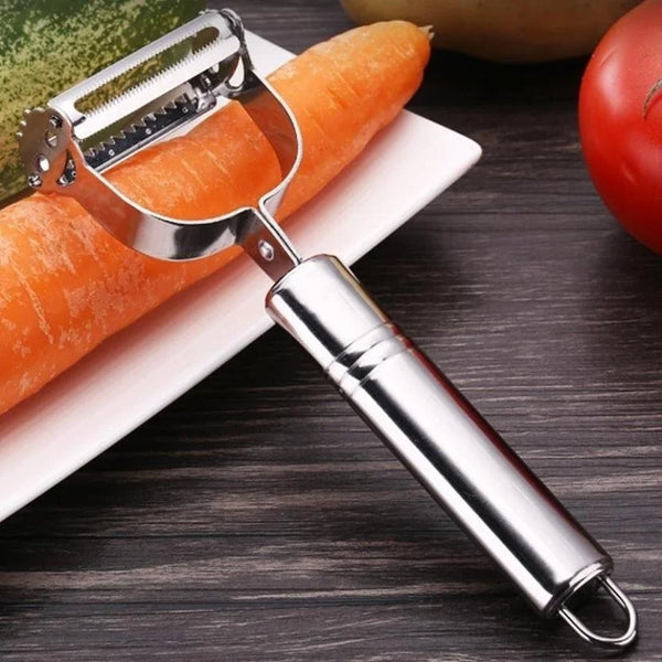 Edelstahl-Gemüsegrater und -schäler mit einer Karotte auf einem weißen Teller