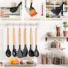 A set of black silicone kitchen tools including spatulas and a knife displayed on a wooden cutting board.