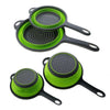 Un juego de tres cestas plegables de silicona verde y gris para colar frutas y verduras.