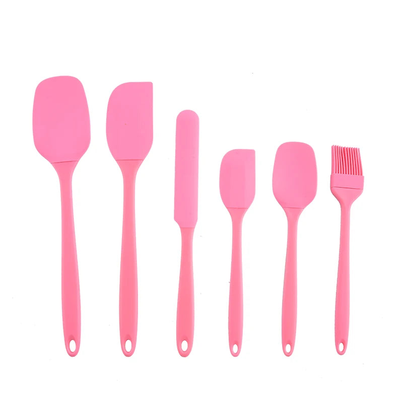 A set of six bright pink silicone kitchen tools for baking and food preparation