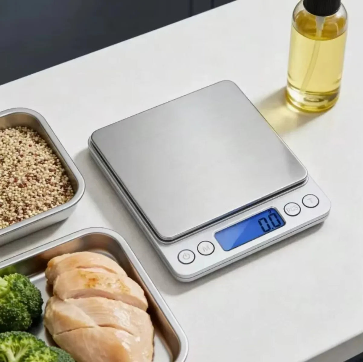 A silver digital kitchen scale is shown next to various food items, including grains, meat, and vegetables.