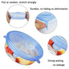 A reusable blue silicone food storage lid being pulled to stretch, demonstrating durability and strong sealing for airtight f